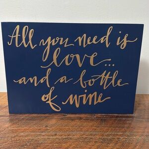 “All you need is love and a bottle of wine” decorative sign